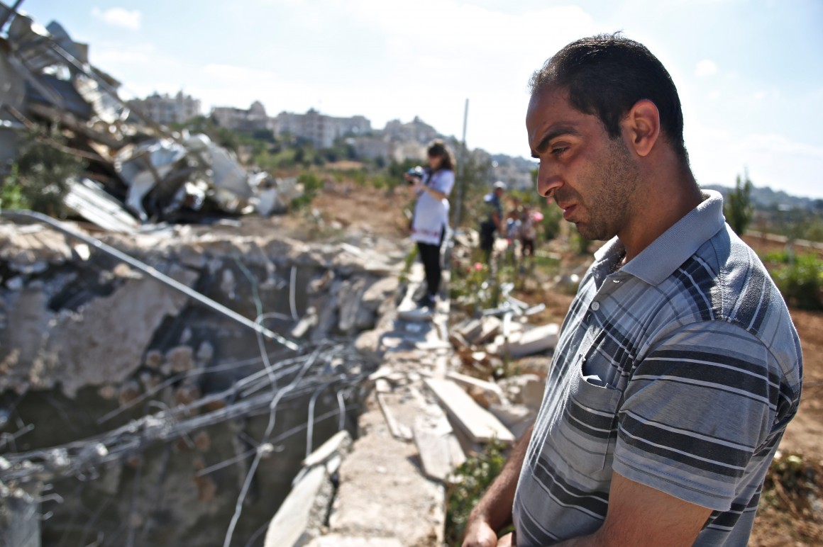 Ataef Al Jabari, a worker employed by the factory looks into the demolished well. (Photo: Kelly Lynn)