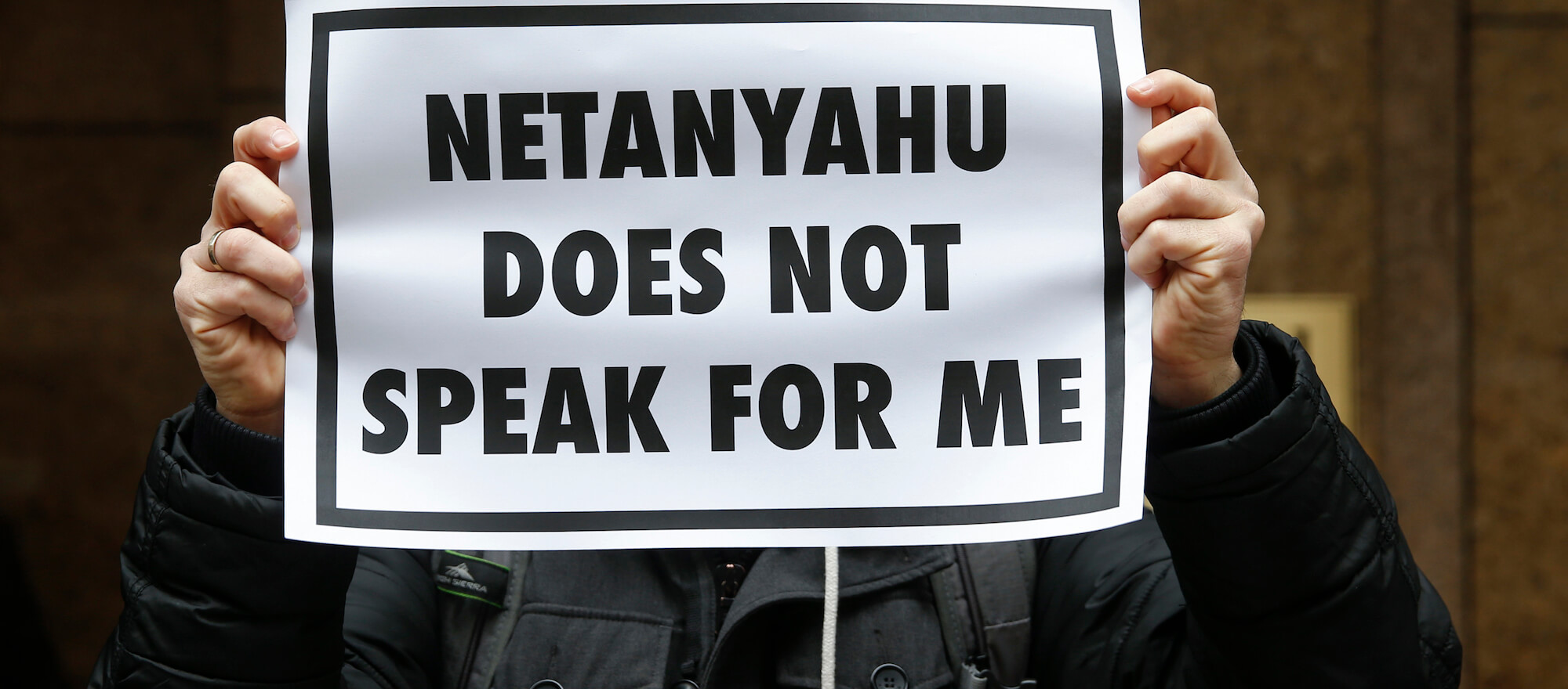 A demonstrator holds a sign during a rally near the Israeli Consulate in New York to protest Israeli Prime Minister Benjamin Netanyahu's speech in front on Congress. (Photo: Shannon Stapleton/Reuters)