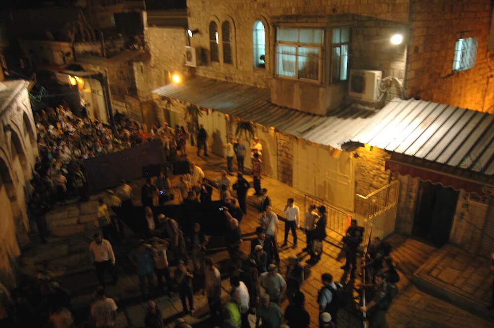 Israeli settlers march through the Muslim quarter in Jerusalem's Old City, Tuesday night. (Photo: Allison Deger)