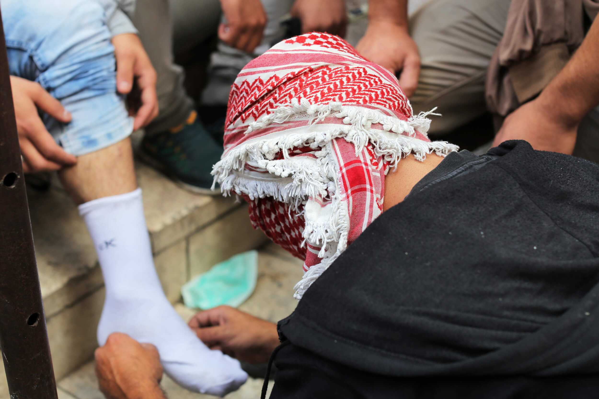 One protester examines the leg of another after he was hit with a tear gas canister during clashes. A hit with a canister can break the skin, cause bruising and chemical burns. (Photo: Abed al Qaisi)