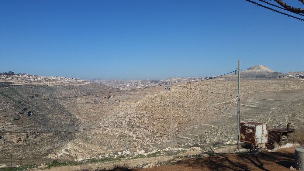 View north from Nokdim settlement in Gush Etzion bloc. Tekoa settlement is at left. In center foreground is security camera; in right background the Herodium