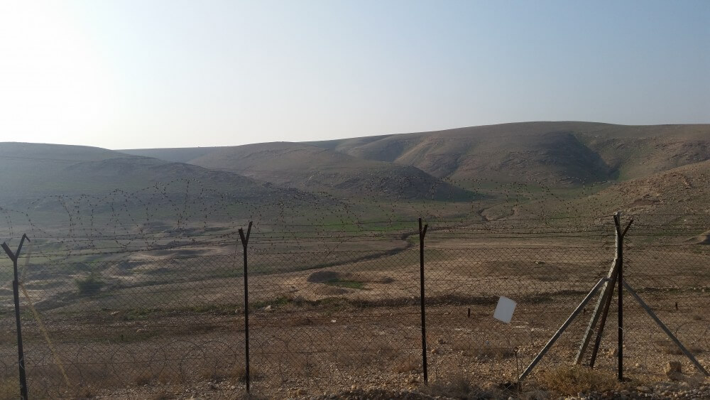 View to the west from kibbutz Na'aran in the Jordan Valley. Beyond security fence is the wadi and Judean hills. 