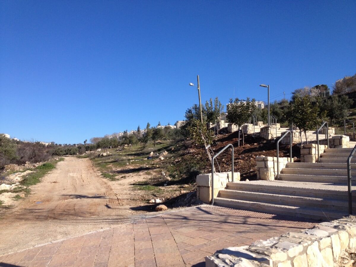 Asphalted pathway leading to Kiryat Arba next to an unpaved pathway leading to Palestinian houses in Wadi Al Hussein (Photo: EAPPI/Sabrina Tucci)