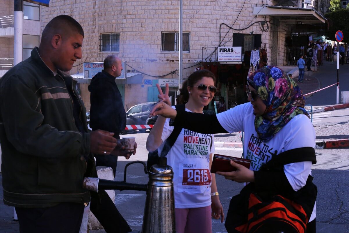 Some runners took the marathon with the upmost seriousness, while others had a bit of fun, like these women buying a cup of coffee in the middle of the race. (Photo: Sheren Khalel/Mondoweiss)