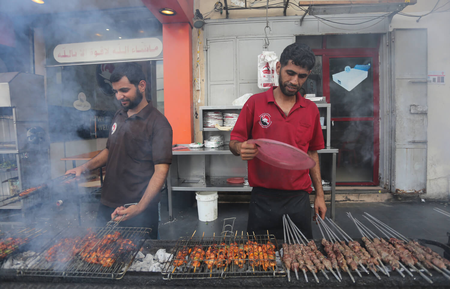 Al-Qasas brothers barbecue in preparation of the iftar meal at a "mashawi" restaurant in Gaza, June 25, 2016. (Photo: Mohammed Asad)