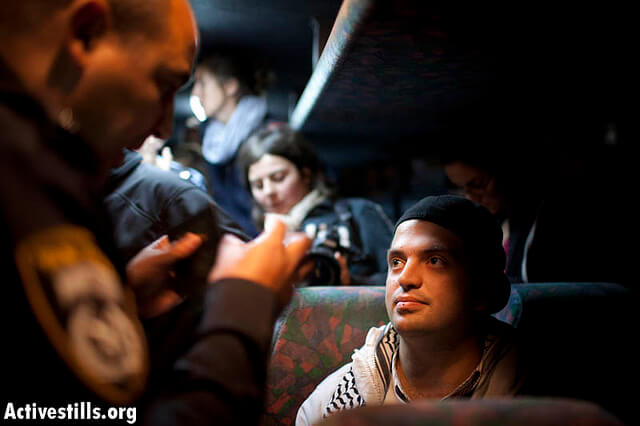Fadi Qura'an facing the Israeli Border Police.  (Photo: Oren Ziv/ Activestills)