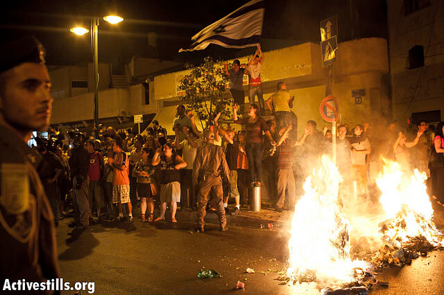 An Israeli mob setting garbage on fire and singing "The people wants the Africans to be burned" after a protest against African refugees and asylum seekers in Tel Aviv's Hatikva neighborhood on May 23, 2012. (Photo: Activestills)