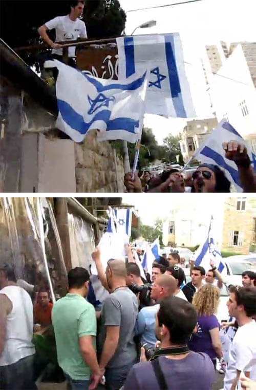 Protesters drape an Israeli flag over the sign to the Azad café and surround patrons, Haifa 2010.