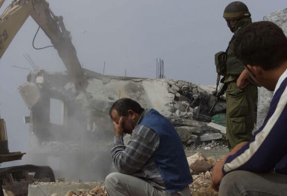 Israeli bulldozers demolish a home in Hebron. (Photo via IMEMC.org)