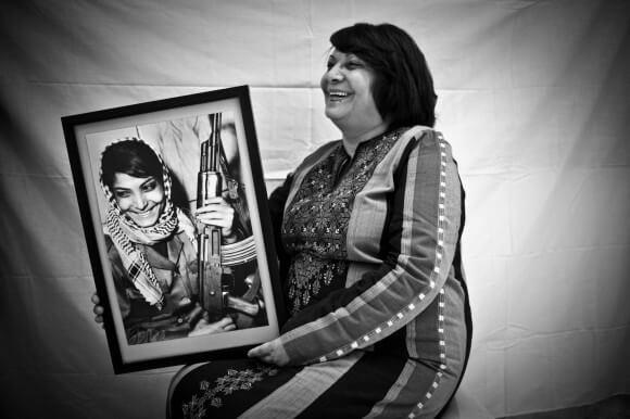 Leila Khaled holding a photo of her younger self in 2009 (Photo: Tanya Habjouqa)