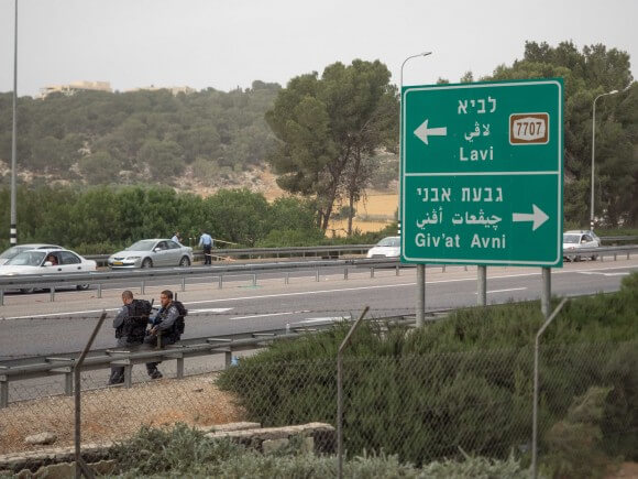 Israeli police sit in front of the sign for the towns built on the site of Lubya. (Photo: Dan Cohen)