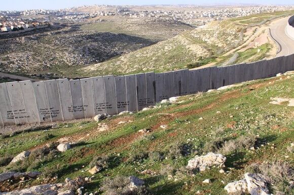 The Separation Wall cuts through the West Bank landscape. (Photo: WIkipedia)