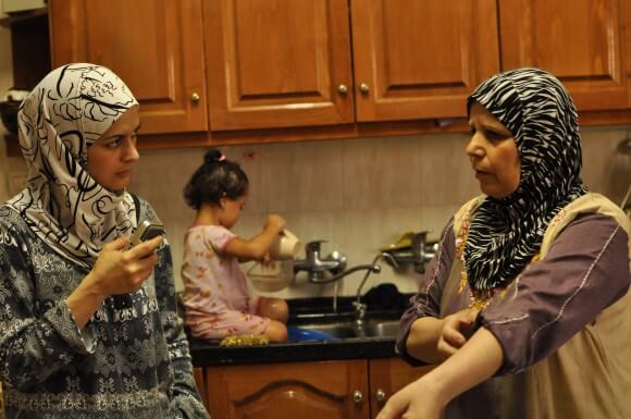 Gaza Kitchen author Laila El-Haddad (left) with Um Ramadan, a Palestinian living in Gaza City whose family is originally from Yaffa. In the background is Laila's daughter Noor. (Photo: Maggie Schmitt)