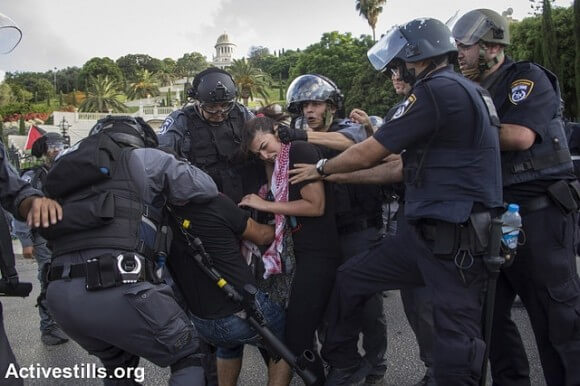 Israeli policemen arrest protesters as Palestnians living in Israel and left wing activists protest against the Israeli attack on Gaza in down town Haifa, July 18, 2014. (Photo: Activestills.org)