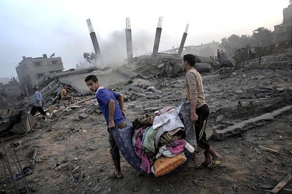 Palestinians collect their belongings from damaged houses in Gaza City. (Photo: Mahmud Hams / AFP / Getty Images)
