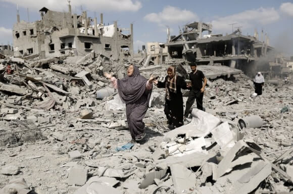 Palestinians in Gaza walk amid destroyed buildings in the northern district of Beit Hanun during an humanitarian truce on July 26, 2014. (Photo: Mohammed Abed/AFP/Getty Images)