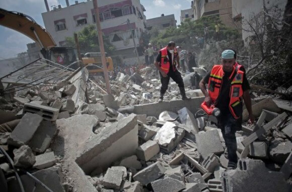 Palestinian rescue workers search for survivors under the rubble of a house was destroyed by an Israeli missile strike, in Gaza City, Monday, July 21, 2014. (Photo: Khalil Hamra/ AP)