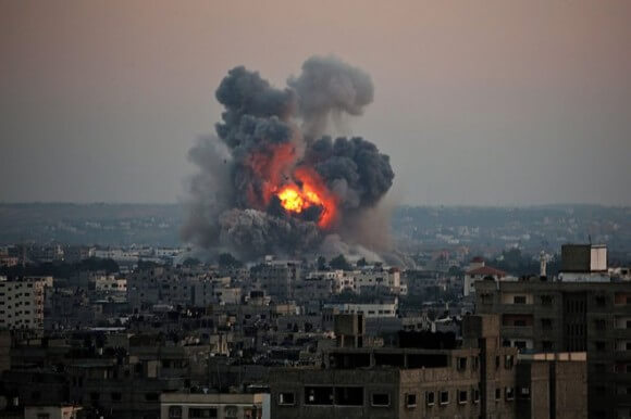 Israel commenced its invasion of the Gaza Strip with air strikes on more than 200 sites, killing 24 Palestinians on the first day. Above, an Israeli missile hits a building just south of Gaza City on July 8, 2014. (Photo: Mohammed Saber, EPA)