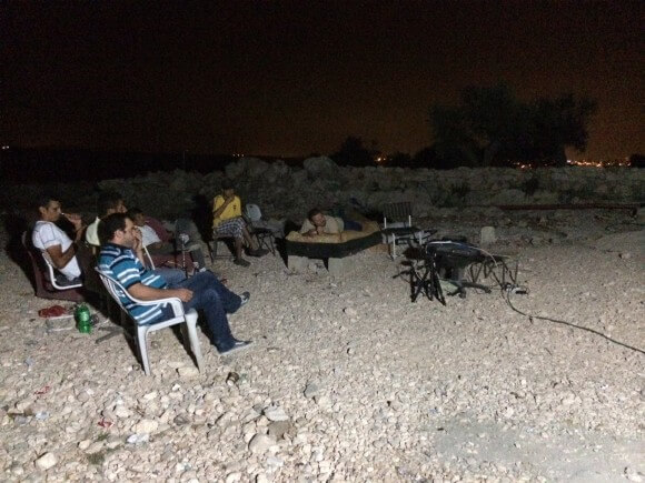 Bil'in residents gather on a hill outside the village to watch the latest news out of Gaza.