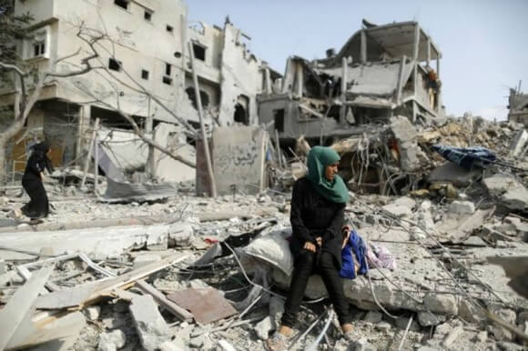 A Palestinian woman sits on the remains of her destroyed house after returning to Beit Hanoun town. (Photo: Reuters) 