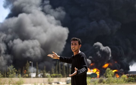 A Palestinian man reacts as a fire burns the only power plant supplying electricity to the Gaza Strip. Israeli shells struck the plant. (Photo: AFP/Getty Images)