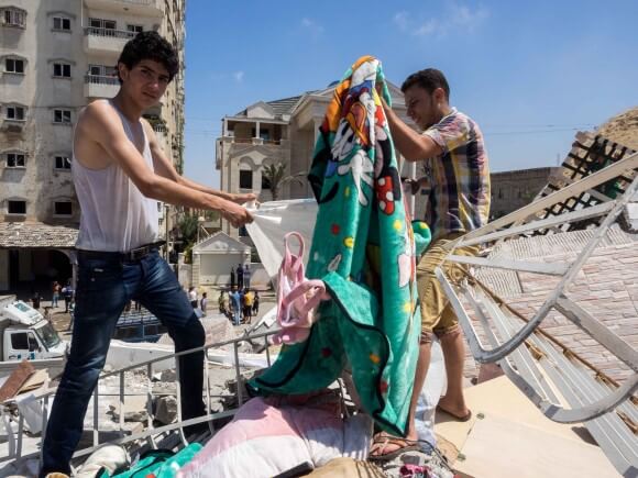 Assad Saftawi and his cousin stuff blankets into a bag. (Photo: Dan Cohen)