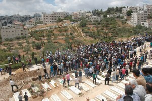 Mourners bury Mohammad al-Qadary at a hillside cemetery in al-Bireh, between Ramallah and the settlement of Pasgot. (Photo: Allison Deger)