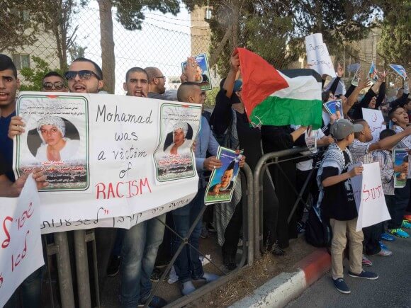 Protesters hold signs outside the Jerusalem courthouse. (Photo: Dan Cohen)