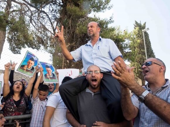  Hussein Abu Khdeir waves the victory sign atop a protester's shoulders. (Photo: Dan Cohen)