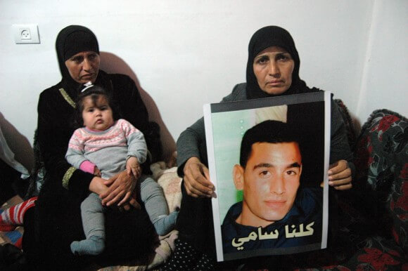 Mother of Sami Ja'ar holds a poster of her son. "We are all Sami." (Photo: Allison Deger)