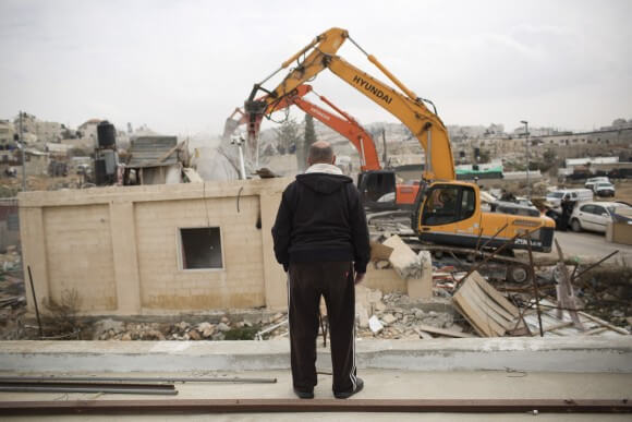 A member of the Adgluni family watching his house being demolished by Israeli authorities in Beit Hanina, East Jerusalem on January 27, 2014. (Photo: Activestills)