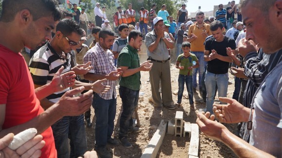 Mourners pray over the grave of Sa’ad Dawabshe after his funeral in the West Bank town of Duma, August 8, 2015. (Photo: Dan Cohen)