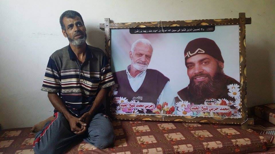 Fathi Eid and poster for his father and brother who were killed in the crime. (Photo: Isra Saleh El-Namy)