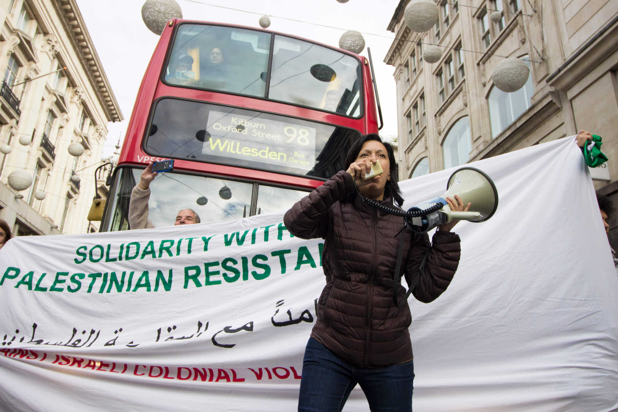 Palestinian artist and activist Rafeef Ziadah stops traffic on Oxford Street. (Photo: Sara Anna)