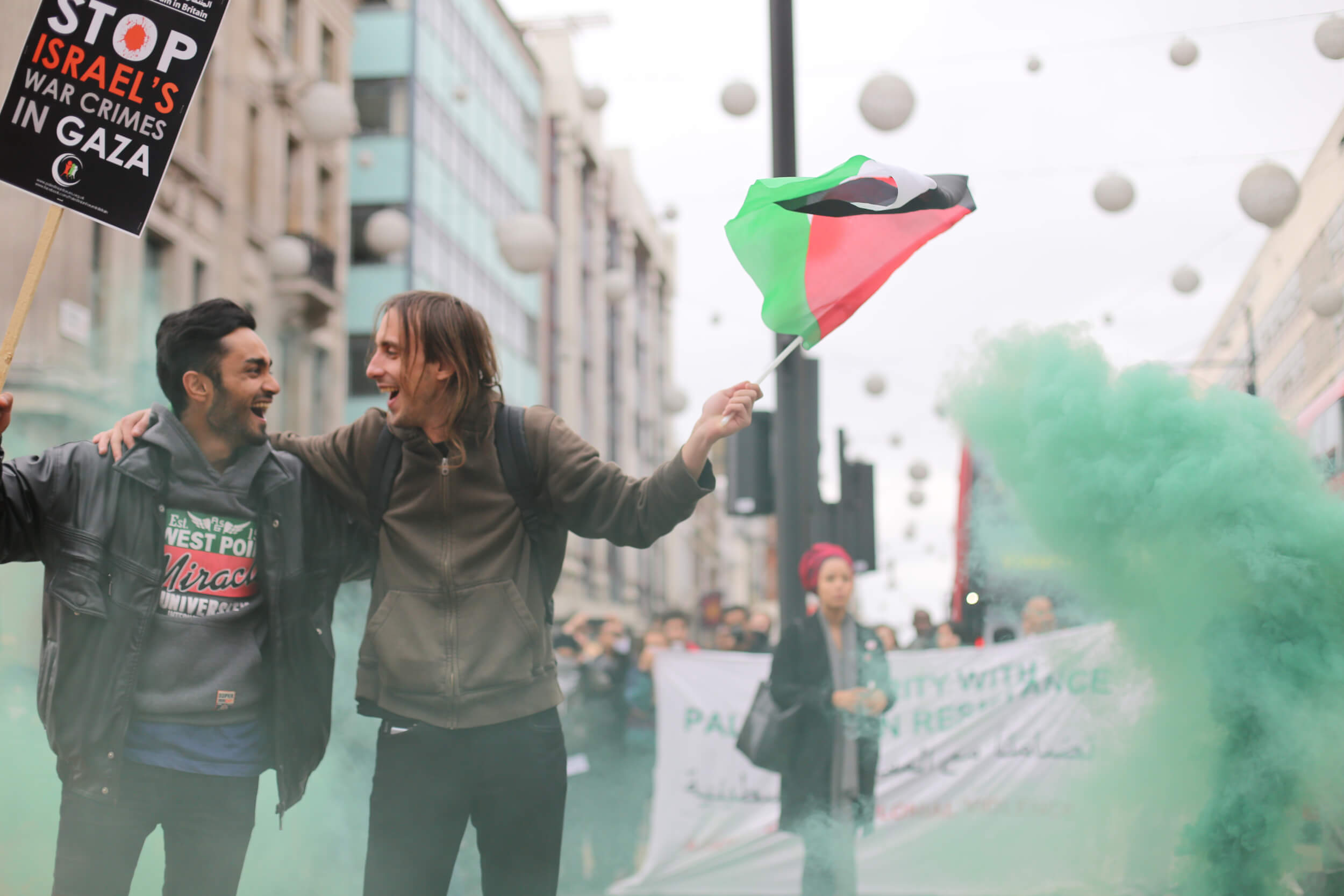 London Palestine Action protestors set off red and green smoke bombs, two of the colours of the Palestinian flag, while blocking traffic at Oxford Circus. (Photo: Sara Anna)