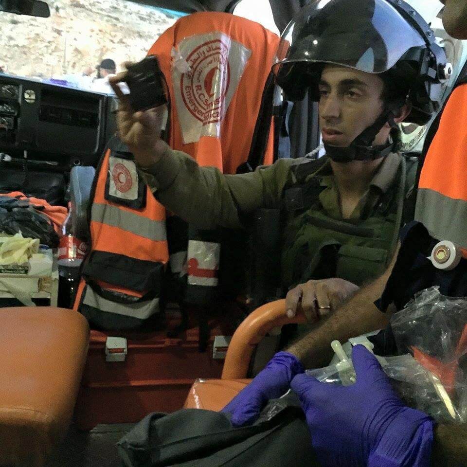 Israeli soldier photographs a Palestinian ambulance during clashes at a West Bank protest, preventing the emergency medical team from transporting a wounded demonstrator, October 6, 2015. (Photo: PRCS)
