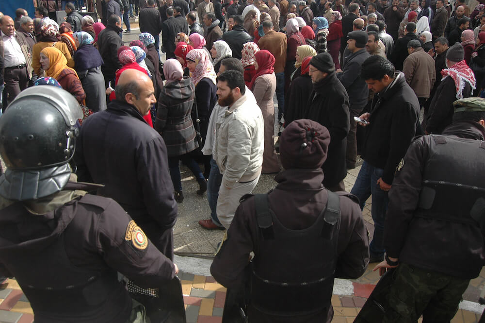 Palestinian teachers march in front of security forces during a demonstration for increased salaries in Ramallah, February 23, 2015. (Photo: Allison Deger)