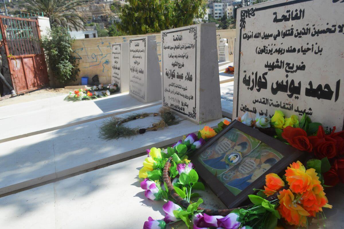 The graves of three cousins killed on the same day. The row nearly hits the front gate of the martyrs cemetery, where space has nearly run out. (Photo: Sheren Khalel)