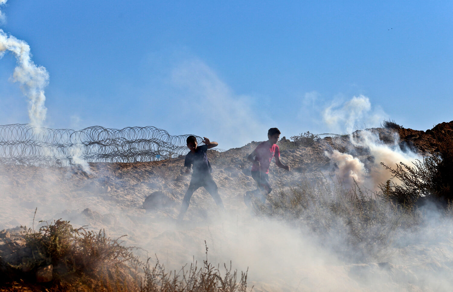 Protesters dodge Israeli tear gas canisters near Nahal Oz, east of the al-Bureij refugee camp in central Gaza Strip, September 30, 2016. (Photo: Mohammed Asad)