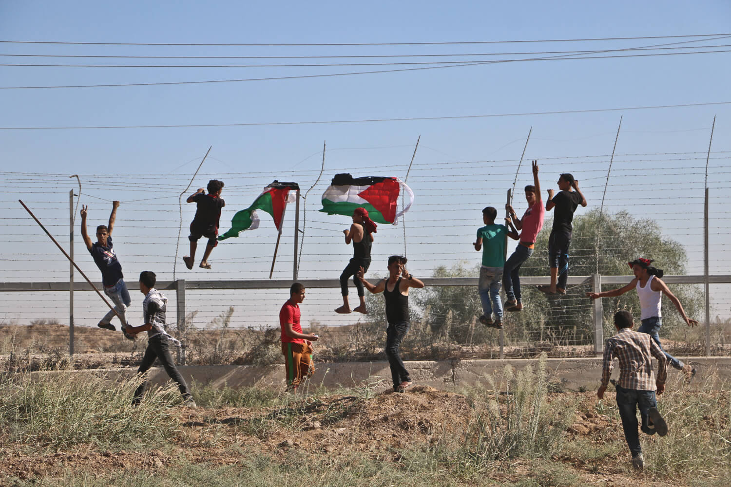Protesters climb the Gaza barrier near Nahal Oz, east of the al-Bureij refugee camp in central Gaza Strip, September 30, 2016. (Photo: Mohammed Asad)