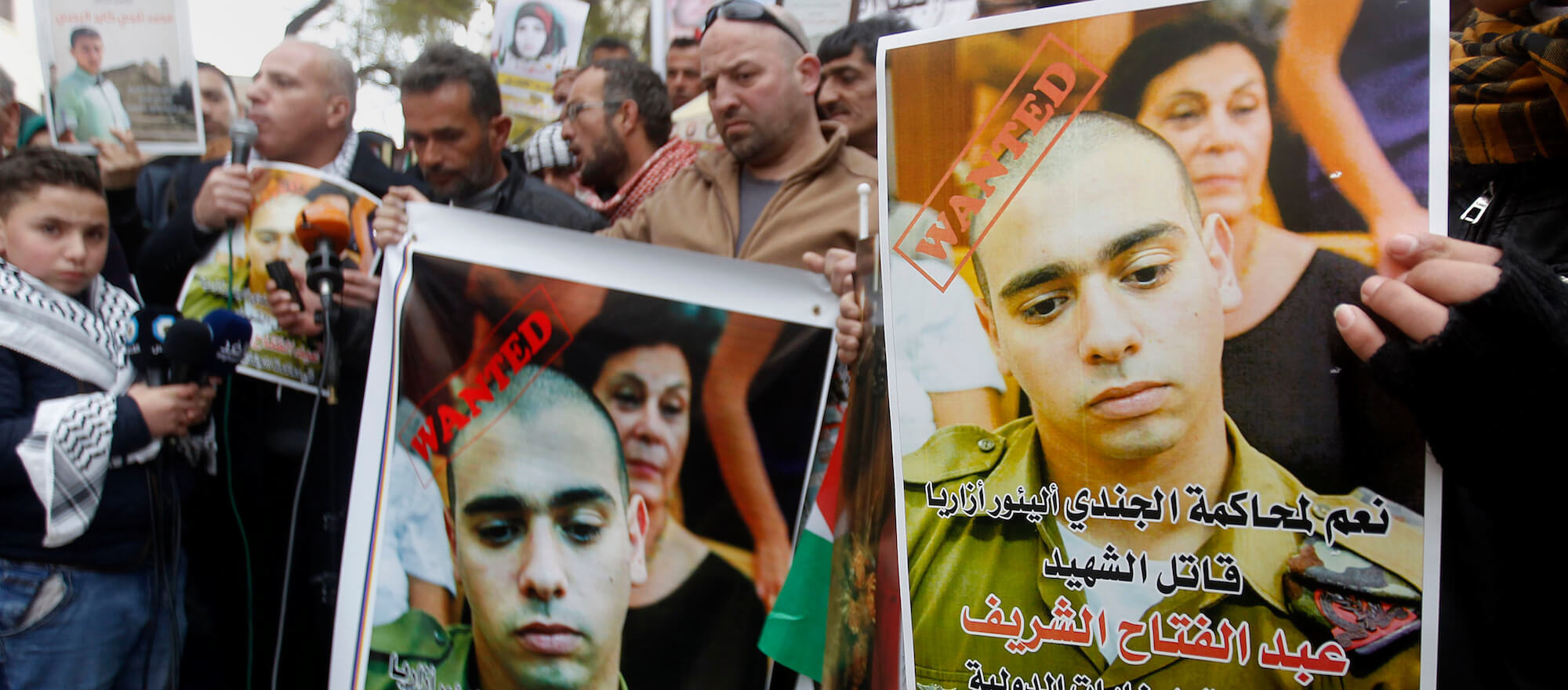 A Palestinian holds a poster of Israeli Sergeant Elor Azaria that reads "wanted". Azaria killed Palestinian Abdel Fattah al-Sharif at point-blank range in the West Bank city of Hebron on January 4, 2017. (Photo by Wisam Hashlamoun/ apa images)