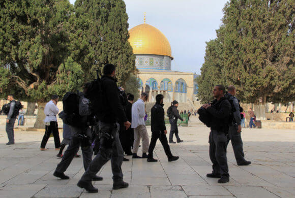 Jewish settlers walk protected by Israeli security forces near Jerusalem's Dome of the Rock mosque in the Al-Aqsa mosque compound on Jan. 11, 2016. (Photo: Mahfouz Abu Turk/ APA Images)