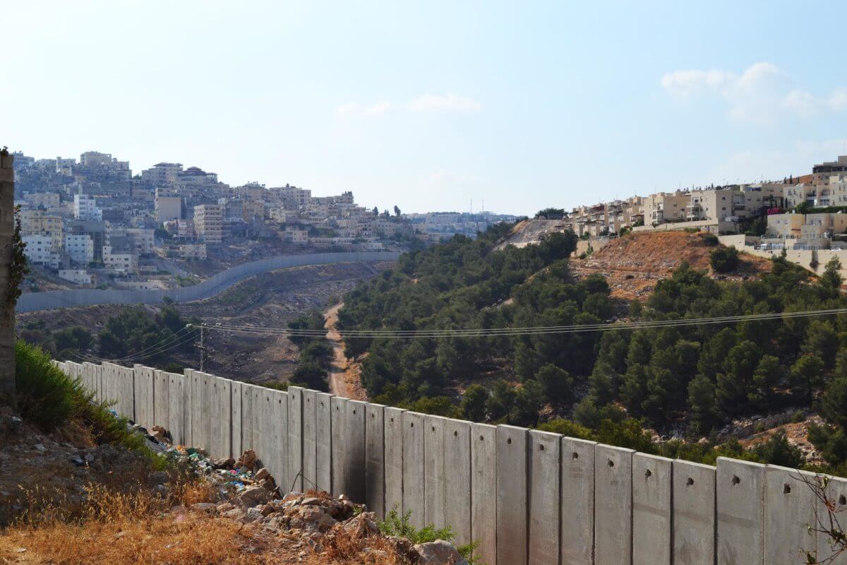 An Israeli settlement sits to the right of Israel's separation wall in East Jerusalem, dividing the Palestinian neighborhood to the left, from other Palestinian neighborhoods in the area. (Photo: Eoghan Rice)