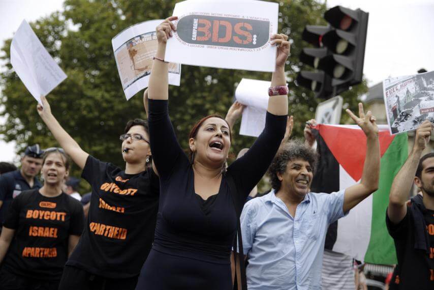 Protestor holds signs supporting BDS, the movement for boycotts, divestment and sanctions against Israel, at 'Tel Aviv sur Seine' in Paris, August 13, 2015. (Photo: Kenzo Tribouillard/AFP/Getty Images)