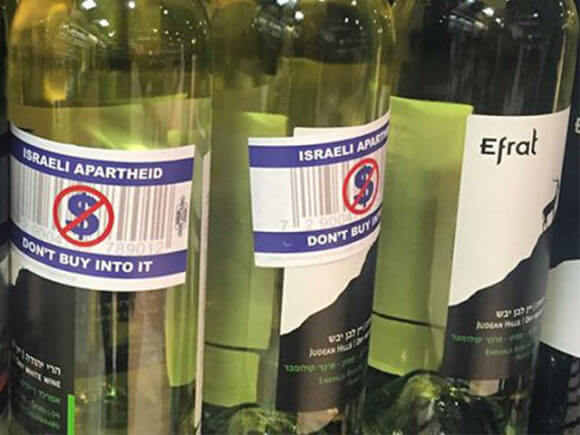 Activist labels pasted across wine produced in the West Bank Israeli settlement of Efrat, originally labeled as "made in Israel." (Photo: Facebook/Canadian Jewish News)