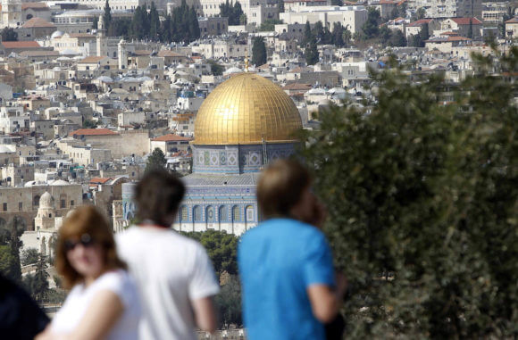 Tourists stand at the Mount of Olives, overlooking the Al-Aqsa mosque compound, in Jerusalem's Old City on November 04, 2014.