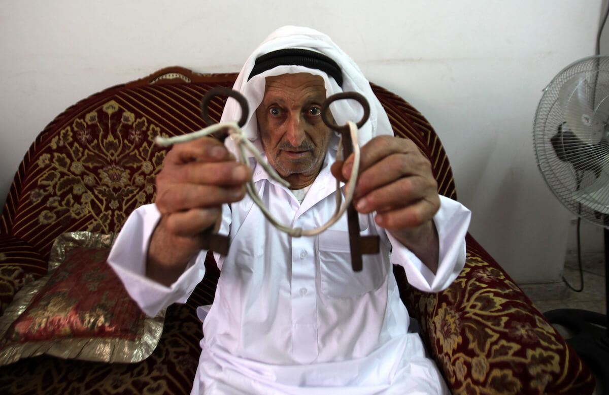 Palestinian refugee Abdulrahim Saad, 82, holds the keys of his former house in the city of Lod as he sits at his home in the West Bank refugee camp of Askar, near Nablus, May 13, 2015. Many Palestinians keep the keys of their former properties as a symbol for both, of what they had to leave behind and to where they once intend to return. (Photo: Nedal Eshtayah/APA Images)