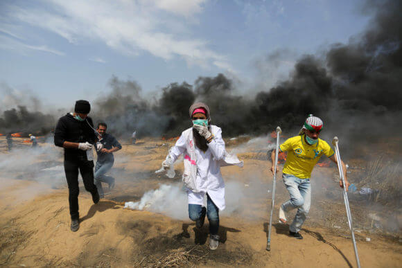 A file photo taken on April 27, 2018 shows Palestinian protesters clash with Israeli security forces during tents protest demanding the right to return to their homeland, at the Israel-Gaza border, in Khan Younis in the southern Gaza Strip. Israel rejected the findings of a UN probe released on February 28 into its soldiers' response to Gaza unrest that began in March last year, calling it "hostile, deceitful and biased." (Photo: Ashraf Amra/APA Images)