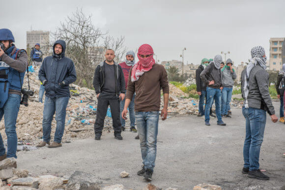 Palestinian protesters gather to throw stones at the northern entrance of Al Bireh, close to the settlement of Beit El. This location is close to a checkpoint, an army base and a refugee camp. It frequently witnesses clashes between the Israeli army and Palestinians. (Photo: Annelies Keuleers)