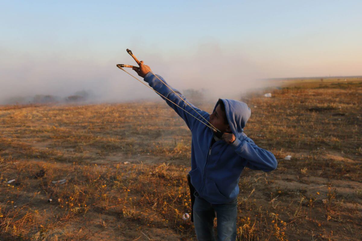 Shooting a sling shot at the Gaza fence, March 22, 2019. (Photo: Mohammed Asad)